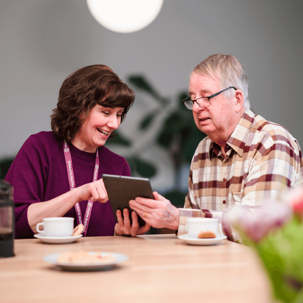 Home Instead care professional using tablet with her client