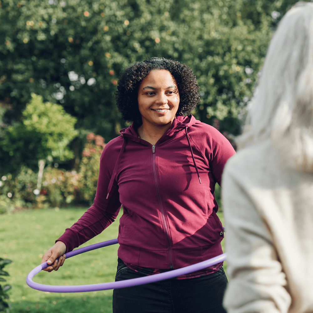A home instead care professional teaching hoop exercises