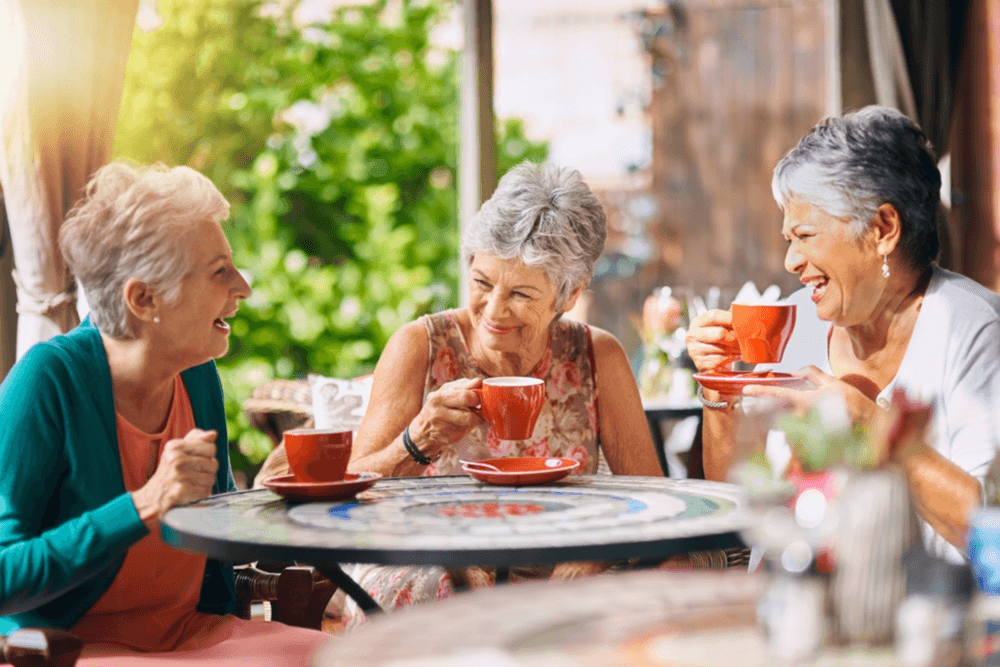 Group of ladies socialising with obvious happiness which helps with brain health