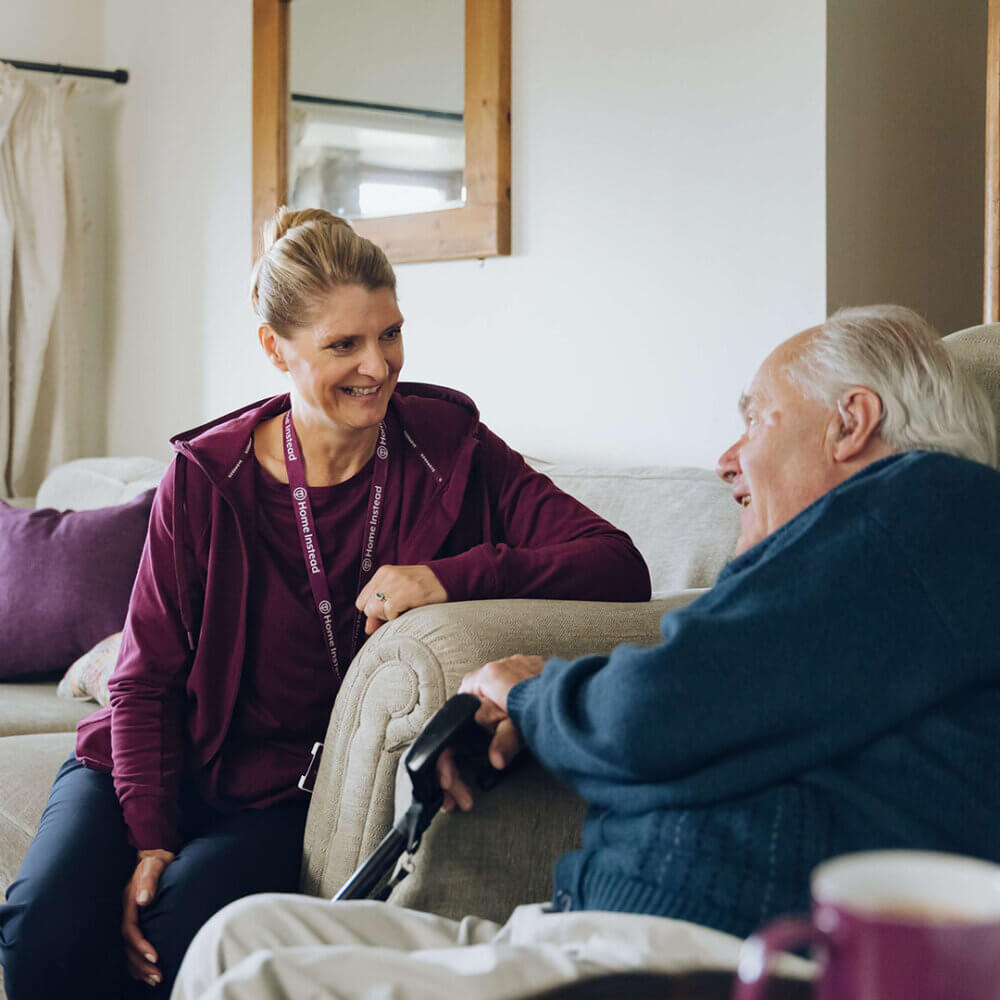 A home instead care professional chatting with an elderly man in his home