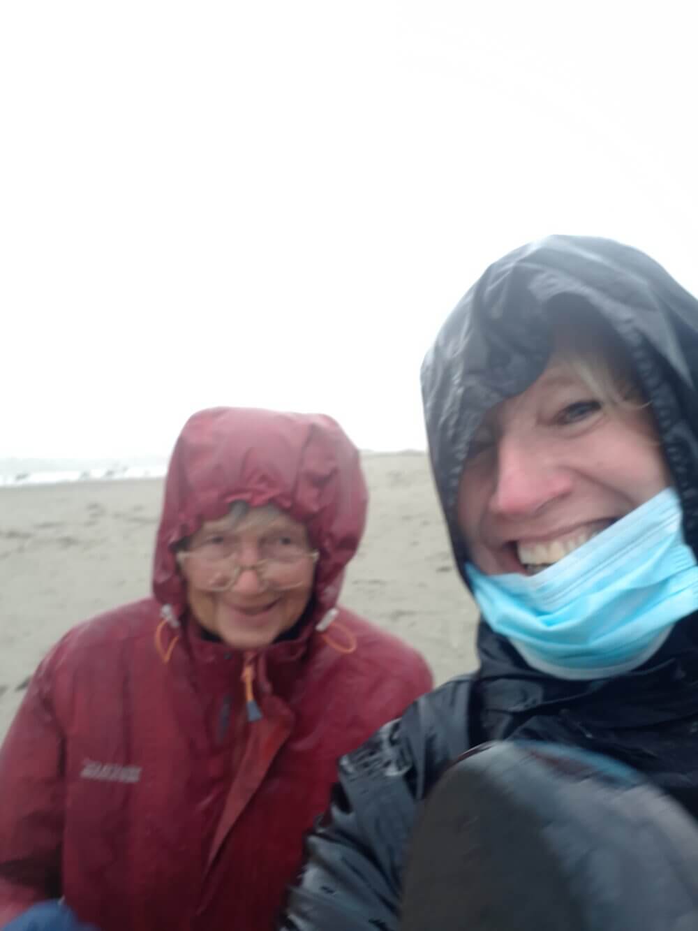 older person with companion carer on the beach in West Wittering