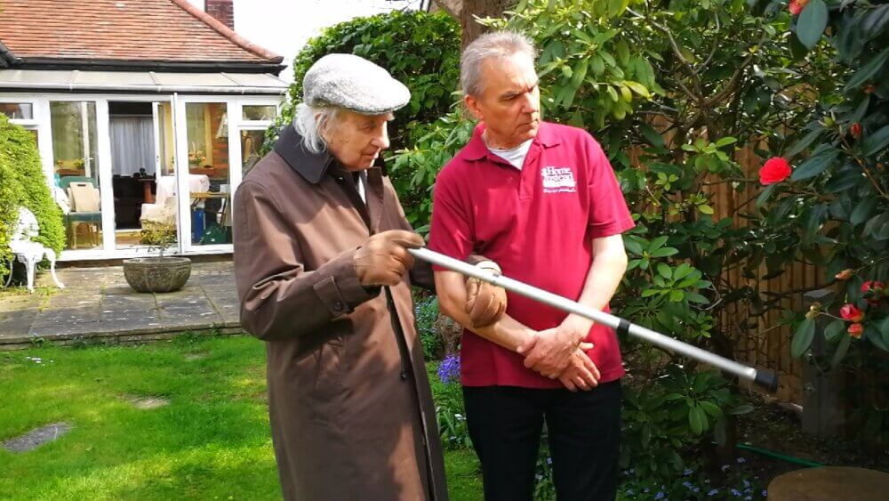 Care assistant and dementia client in garden